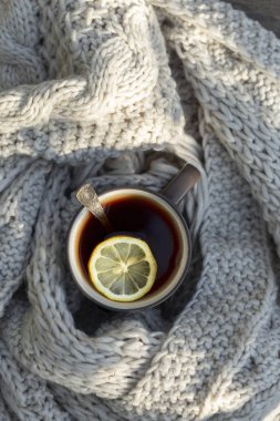 Ahşap arka plan açık, limon, örme eşarp ile çay