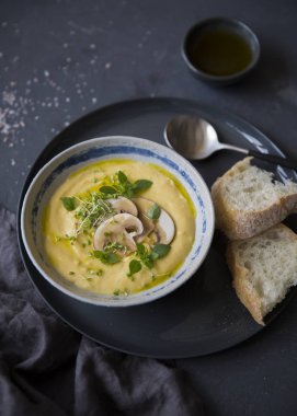 Mantar, otlar ve gri plaka siyah arka plan üzerine beyaz ekmek ile krem peynir çorbası