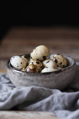 Bıldırcın yumurtası gri peçete koyu arka plan, gri kase