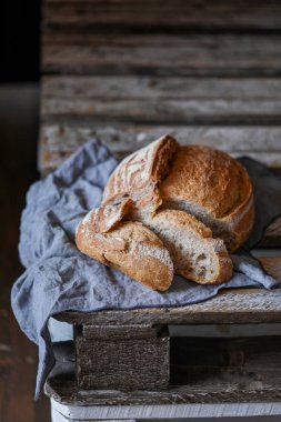 Ekmek masada koyu arka plan üzerinde beyaz peçete ile ahşap panosu dilimleri ile
