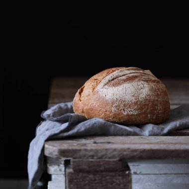 Ekmek masada koyu arka plan üzerinde beyaz peçete ile ahşap panosu dilimleri ile