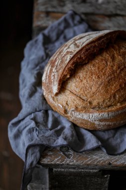 Ekmek masada koyu arka plan üzerinde beyaz peçete ile ahşap panosu dilimleri ile