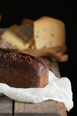 Siyah tahıl ekmek peynir ve beyaz peçete koyu arka plan üzerinde masada ile