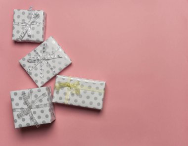 Bezelye, pembe bir arka plan, metin için şablon üstten görünüm, sınır tasarlamak kopya alanı ile altın ve gümüş yay ile hediye kutuları