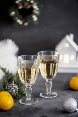 İki kadeh şampanya gri arka plan, tinsel, mandalina, koni ve Noel oyuncak yakın ile. Noel kompozisyon