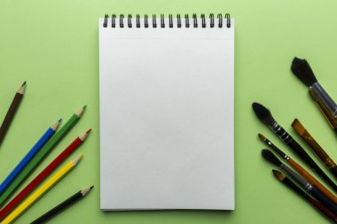 Renkli kalem ve fırça ile yeşil zemin üzerine not etmek. Uzay kopyalayın. Metin için şablon