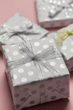 Bezelye, pembe bir arka plan, metin için şablon üstten görünüm, sınır tasarlamak kopya alanı ile altın ve gümüş yay ile hediye kutuları