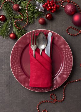 Noel ve yeni yıl kırmızı tabak, çatal, kaşık ve bıçak ile Noel ağacı dalı ve Noel oyuncaklar ahşap arka plan, kırmızı peçeteye hizmet veren. Tatil yemek. Tablo küme.