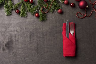 Noel ve yeni yıl kompozisyon çatal ve bıçak ile Noel ağacı dalı ve Noel oyuncaklar ahşap arka plan, kırmızı peçeteyle hizmet. Tatil yemek. Tablo kümesi. Uzay kopyalayın. Şablon. dekorasyon öğesi ve kopya alanı