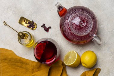 Limonlu, cam Çaydanlık, hibiscus çay (pembe, Agua de flor de Jamaica) şeffaflık bardak tatlım tatlım sopa ve turuncu peçete, ışık arka plan ile. Taze çay saati kompozisyon. Sağlıklı yaşam kavramı