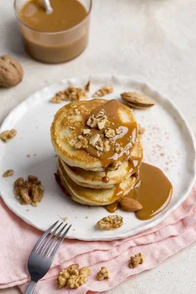 Karamel ve ceviz beyaz tabakta krep yığını. Festival gıda kavramı shrove