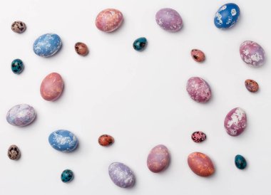 Yaratıcı çerçeve arka plan kopya alanı için metin ile bıldırcın, pembe, mor ve mavi Paskalya yumurtaları ile. Beyaz arka plan üzerinde izole. Düz yatıyordu, en iyi görünümü.