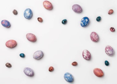 Yaratıcı çerçeve arka plan kopya alanı için metin ile bıldırcın, pembe, mor ve mavi Paskalya yumurtaları ile. Beyaz arka plan üzerinde izole. Düz yatıyordu, en iyi görünümü.