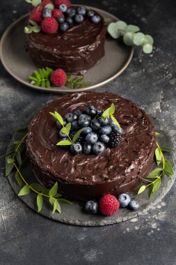 Çikolatalı kek çilek ve yeşil gri plaka üzerinde yapraklar