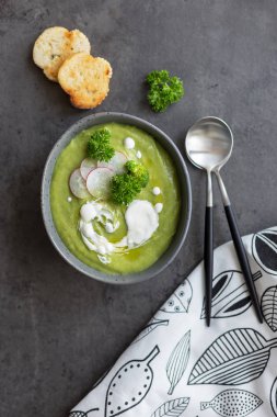 Gri arka planda brokoli ve krema ve kaşık ile Çorba
