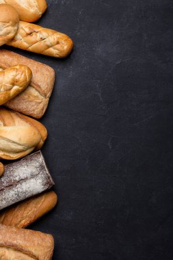 Koyu masada taze ekmekler.