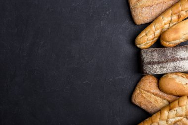 Kopya alanı ile rustik koyu arka plan üzerinde farklı ekmek