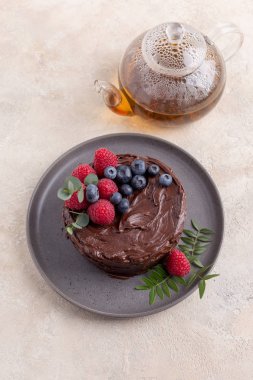 Parlak arka planda gri plaka üzerinde ahududu ile Çikolatalı kek