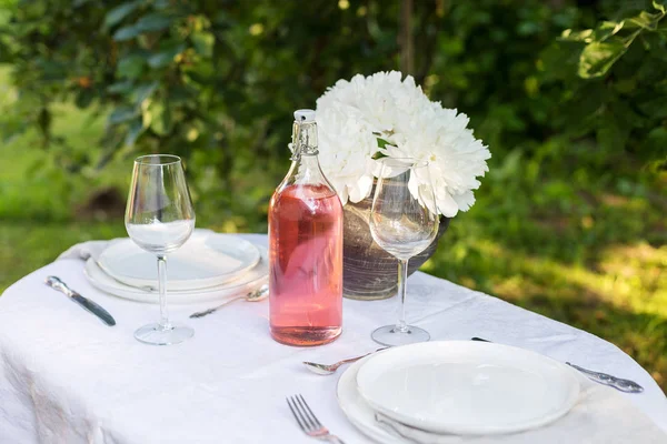 Сервировочные тарелки со столовыми приборами на белой ткани снаружи — стоковое фото