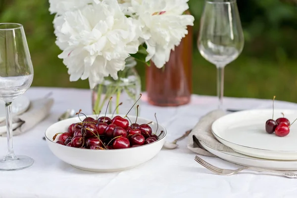 Ciotola bianca con ciliegia dolce sul tavolo con panno bianco — Foto Stock
