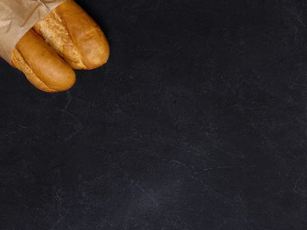 Bread at black background in left corner — Stock Photo, Image