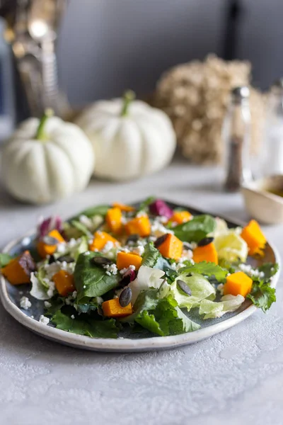 Fırında kabak kabak, ıspanak, beyaz peynir ve kabak çekirdeği ile yeşil salata plaka