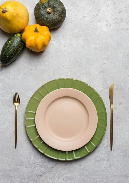 Piatto vuoto con forchetta e coltello e zucche — Foto Stock