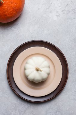 Gri arka planda kabak ile mevsimlik boş tabak