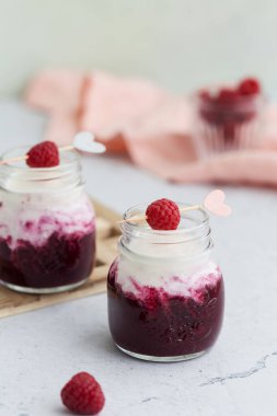 Hafif arkaplanda meyve püresiyle süt ve yoğurdu karıştırın..
