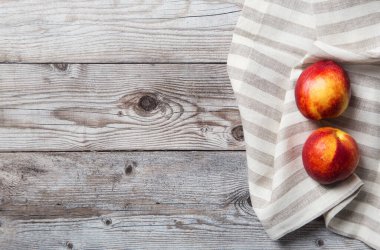 Copy space with two nectarines with towel on wood background. Concept of harvest backdrop for market sale