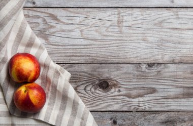Wooden background with smooth peaches at towel. free space for text. Top view, flat lay. Concept of crop backdrop