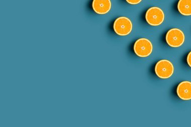 Köşesinde olgun portakal meyvesi ve mavi arka planda minimum modern desen var. Taze çiğ meyve yemeği kavramı. Düz konum, üst görünüm, metin için boşluk kopyala