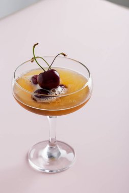 Minimum kokteyl içeceği ve pembe arka planda tatlı kirazlı cam. Süslü kokteyl içeceği kavramı