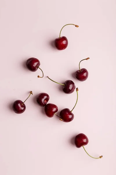 sweet cherry at minimal pink background. Group of berries at soft solid background. Concept of healthy summer harvest food
