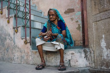 Varanasi, Hindistan - 29 Mayıs 2017: merdivenlerde oturan eski Hint kadın
