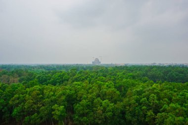 Yeşil orman ve yapım aşamasında uzaktan Vedik planetarium. Mayapur, Hindistan