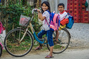Quang Binh Province, Vietnam - 26 Ocak 2018: Vietnamlı çocuklar okuldan sonra eve bisikletle biniyor.