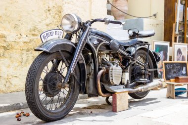 Siyah klasikleri motosiklet Rodos adasının eski şehir souver dükkanı ve resim sergisi yakınında duruyor. Elle çizilmiş klasik motosiklet. Görüntülenebilir insan yok..