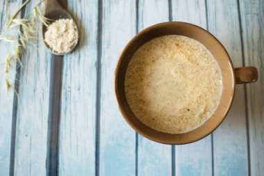 Sağlıklı kahvaltı. Yulaf lapası kase ve doğal ahşap zemin üzerine kaşık