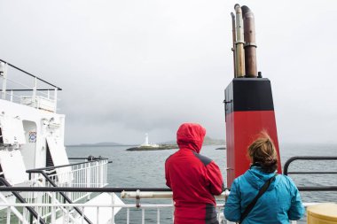 İki turist Inner Hebrides bir feribot geçiş sırasında Lismore deniz feneri görünüyor