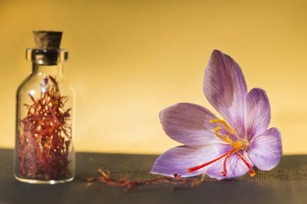 サフランの花と背景の金で ボトルの乾燥サフラン スパイス — ストック写真