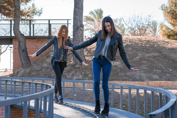 Concept of friendship and happy people - two happy girls make balance in the shape of a train