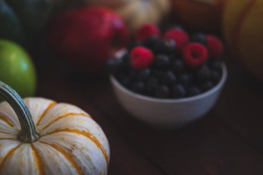 Yaban mersini ve ahududu koyu kahverengi masada kase.