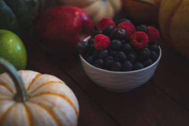 Yaban mersini ve ahududu koyu kahverengi masada kase.