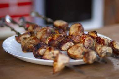 Gazebo içinde masada şişler üzerinde sinirli lezzetli kızarmış domuz kebap