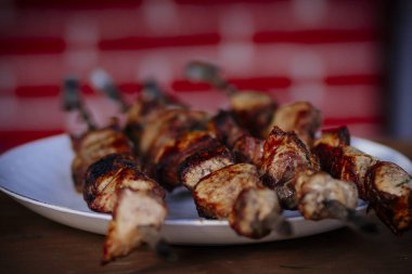 Gazebo içinde masada şişler üzerinde sinirli lezzetli kızarmış domuz kebap