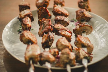 Gazebo içinde masada şişler üzerinde sinirli lezzetli kızarmış domuz kebap