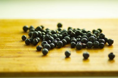 Ahşap bir tahta üzerine dağılmış siyah yaban mersini