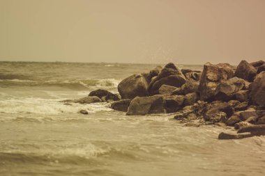 Sıcak Pasifik Okyanusu 'nun pitoresk sahillerinde büyük kayalar ve güçlü dalgalar.