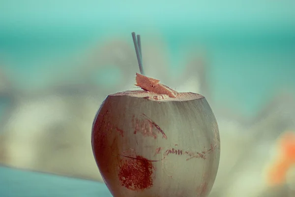 Coconut with a tube on the windowsill of the hotel by the sea